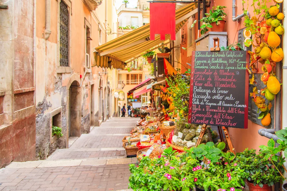 A local shop that sells plants and fruits with a signboard on its storefront, an image for an article that tackles the safety in visiting Sicily.