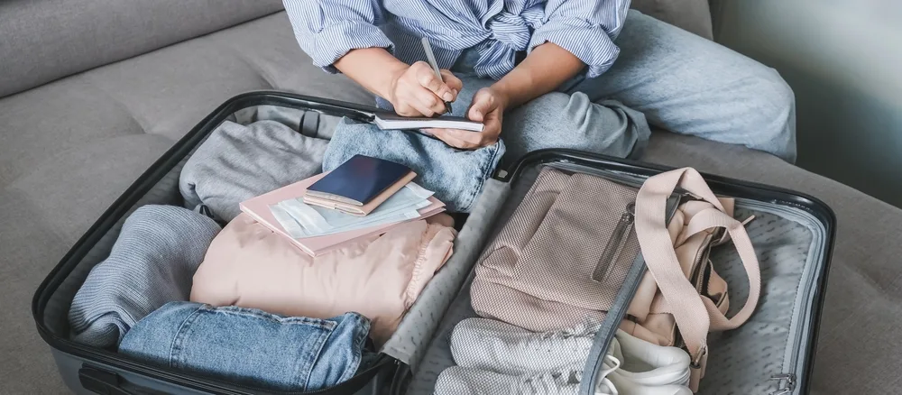 A person doing her check list after packing everything on her luggage, our pick on the image on the guide on how to pack for a trip to Europe.