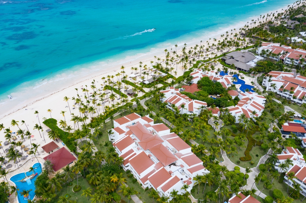Aerial view on a beautiful beach with white sand and calm beach and several hotels. 