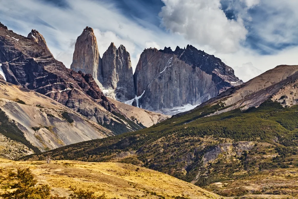 A unique mountain formation, a side of one mountain is covered with trees and some are bare rocks, captured for a piece on an article about trip cost to Patagonia.