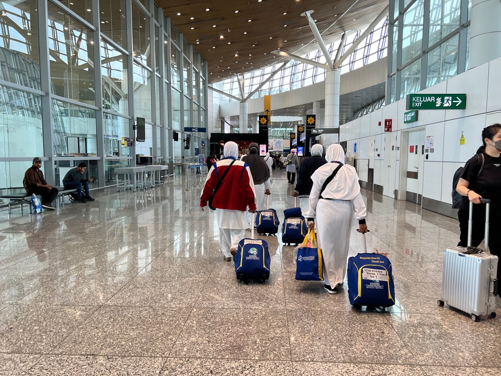 A group of muslim women dragging their luggage bags in the airport. 