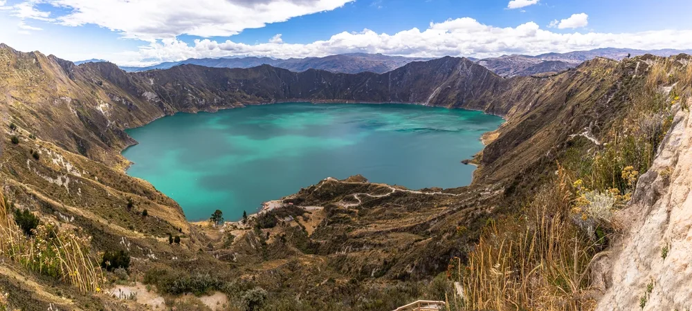 A very large lake surrounded by mountains, camping on the mountains is one of the things to do in Ecuador, an image for an item on the list of facts about the country.
