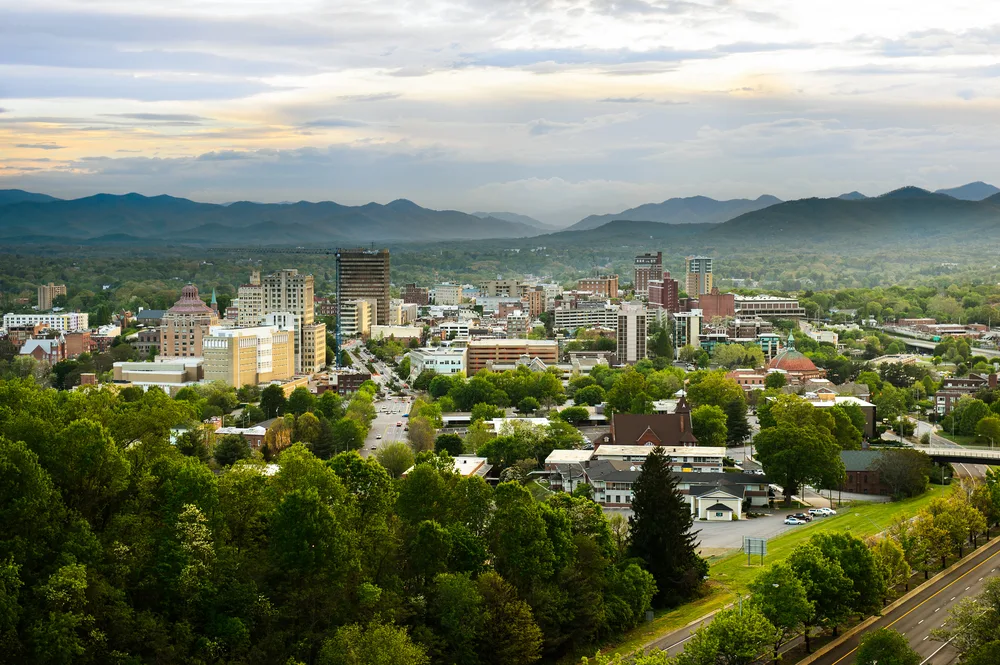 Aerial view of the Asheville, NC skyline with mountains in the distance and fog for a list of the best weekend trips in the US Southeast region