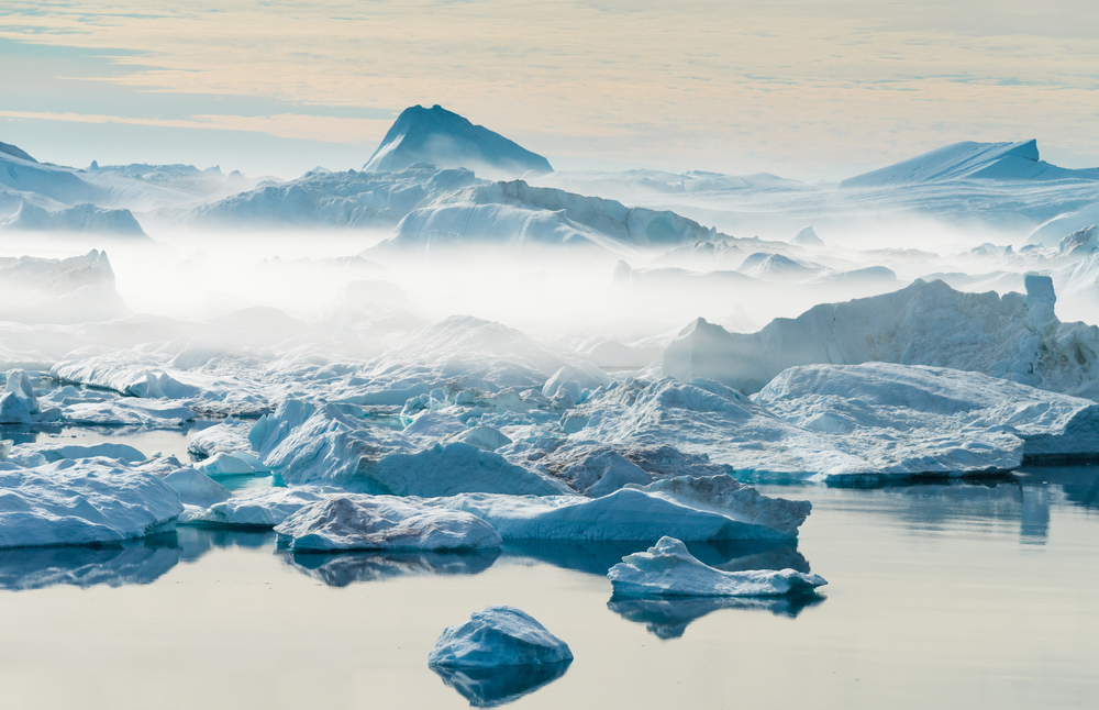 Icebergs in Ilulissat, one of the best areas to stay in Greenland, mists are hovering above the ice due to freezing temperature.
