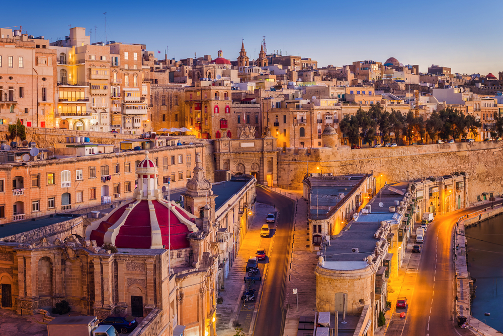 an old town in Valletta, one of the best areas to stay in Malta, during dusk with an elevated landscape and old structures.