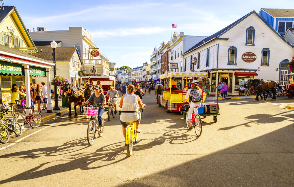 Photo of people mulling about on bicycles and on foot in Mackinac Island, one of the best weekend trips in America