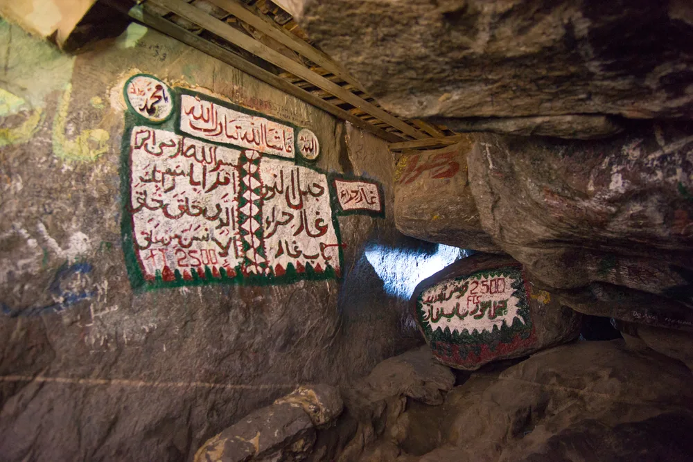 A cave with islamic writings on its walls. 