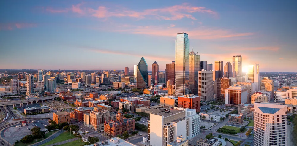Aerial view of a rich city with tall and modern structures during sunset, an image for an article about trip cost to Texas.