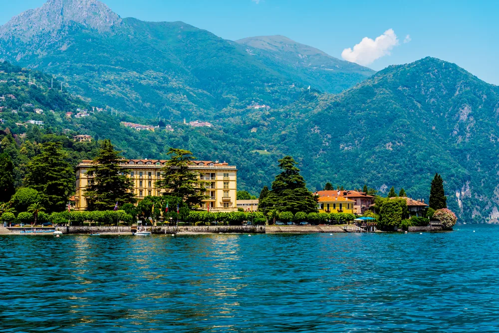 A lake town with a few structure and a background of a tall mountain on Mennagio, a top pick for where to stay in Lake Como