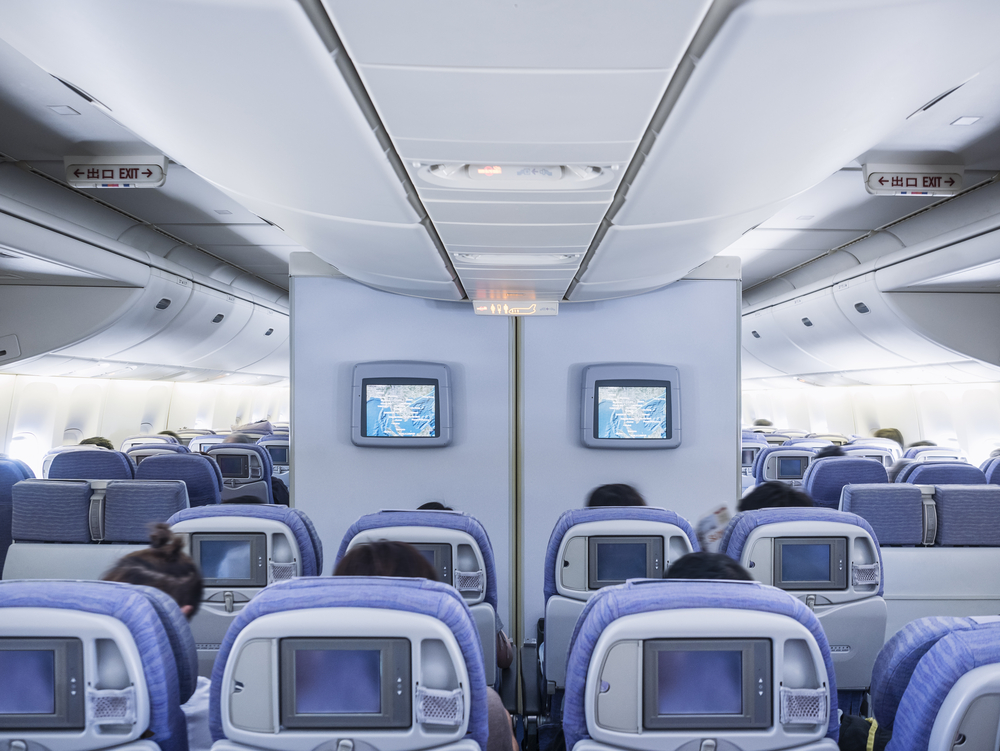 Image showing the concept of front row bulkhead seats with screens on the wall and empty seating behind and around it for a guide answering what is a bulkhead seat?