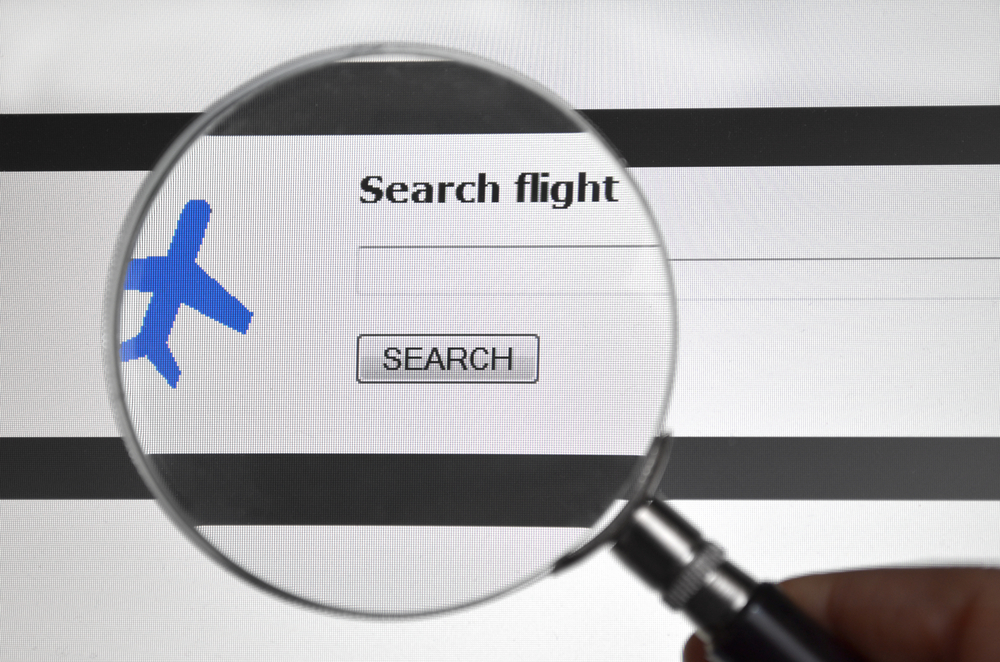 Close-up magnified image reading "search flight" with blue plane icon for a guide explaining how to cancel a flight with different airlines 