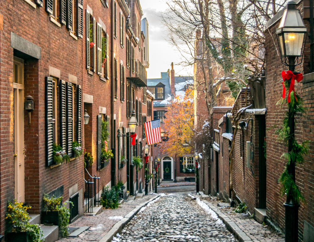 Picturesque Acorn Street pictured in the middle of winter with snow on the ground and tall Colonial style homes on either side