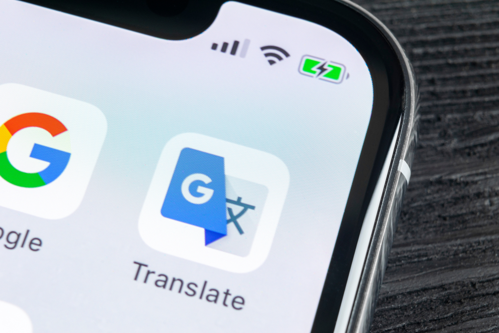 A Google Translate app visible on the iPhone screen. 