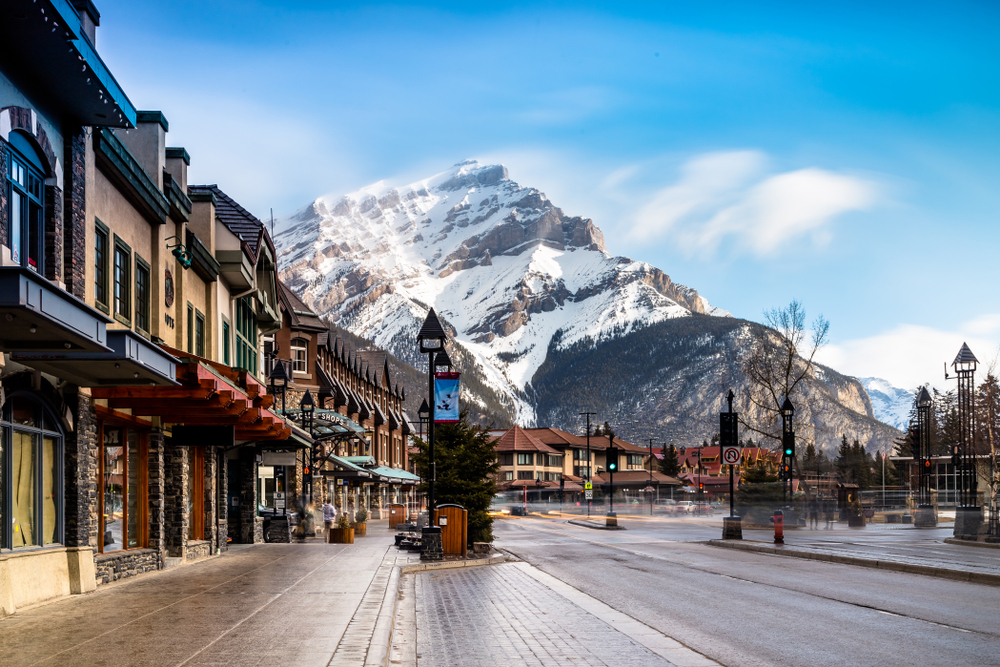 Empty street in the spring at Banff National Park with a snowy mountain in the background