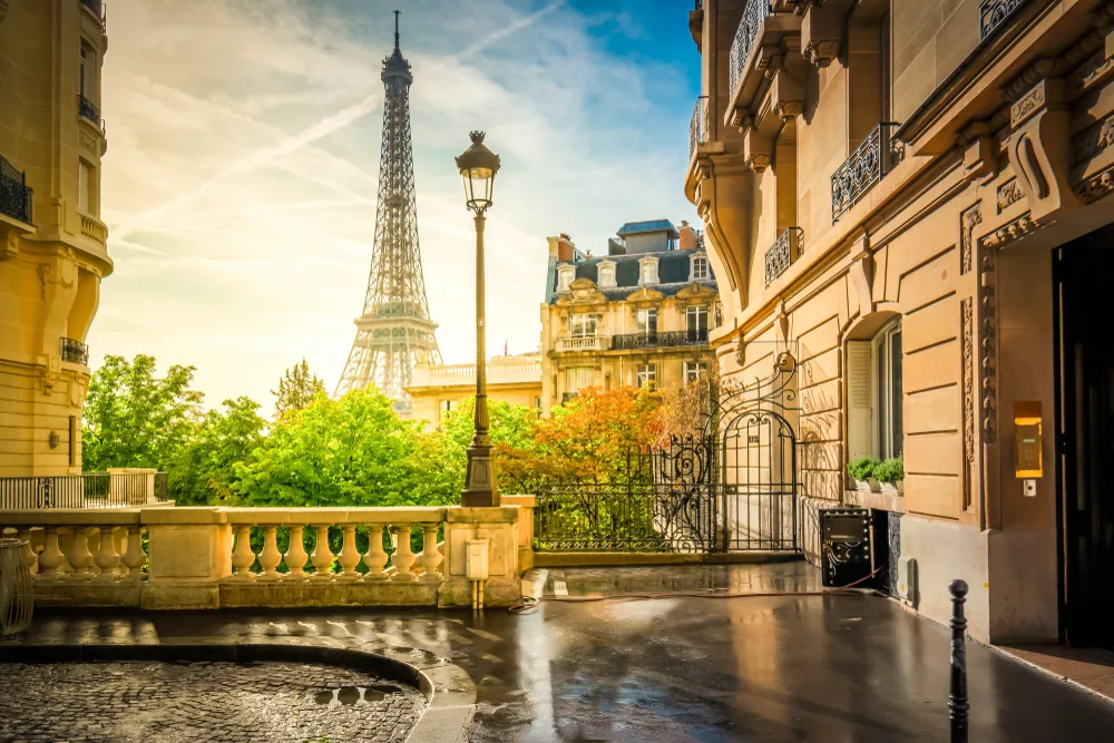 Parisian street view during Golden Hour with the Eiffel Tower in the distance for a Europe itinerary 2 weeks example to Rome, Paris, and London