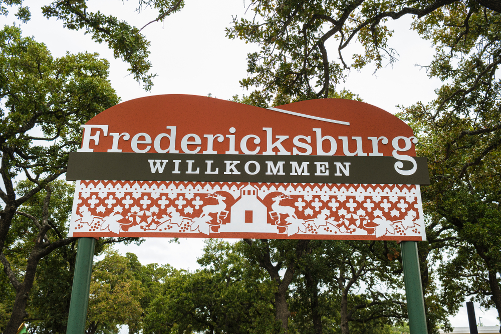 A large signage surrounded by trees that says Fredericksburg Willkommen. 