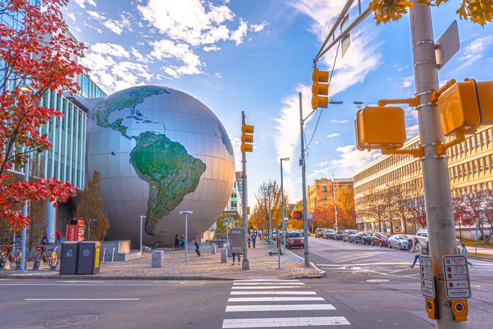A large globe sculpture placed in front of a building. 