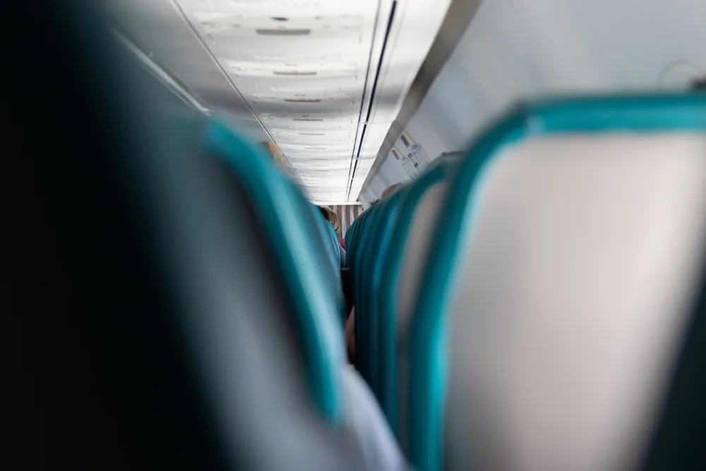 Empty seats with teal piping on a Hawaiian flight to Kauai for an FAQ section on which airlines fly to Hawaii 