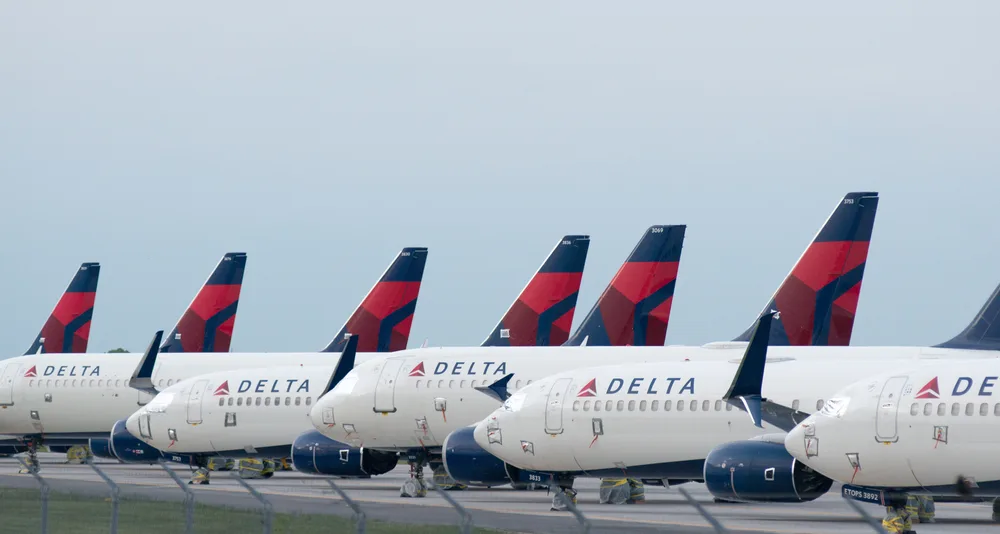 Delta airplanes standby in an airport. 