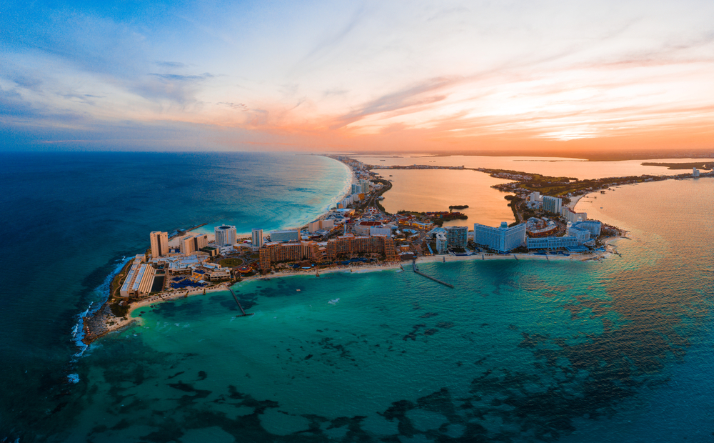 Aerial view of Cancun with resorts and beaches in view at sunrise for a section asking are there direct flights to Cancun