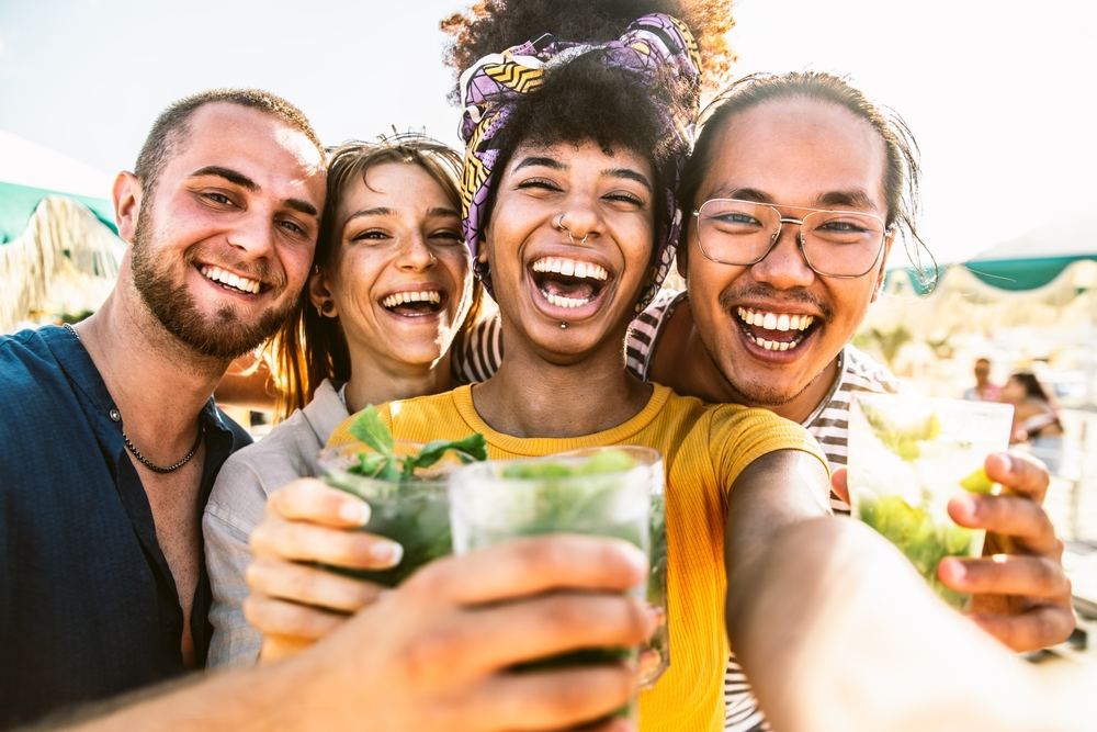 A group of friend doing a group photo while each is holding a glass of drinks, a picture for the guide about the legal drinking age in the Bahamas.
