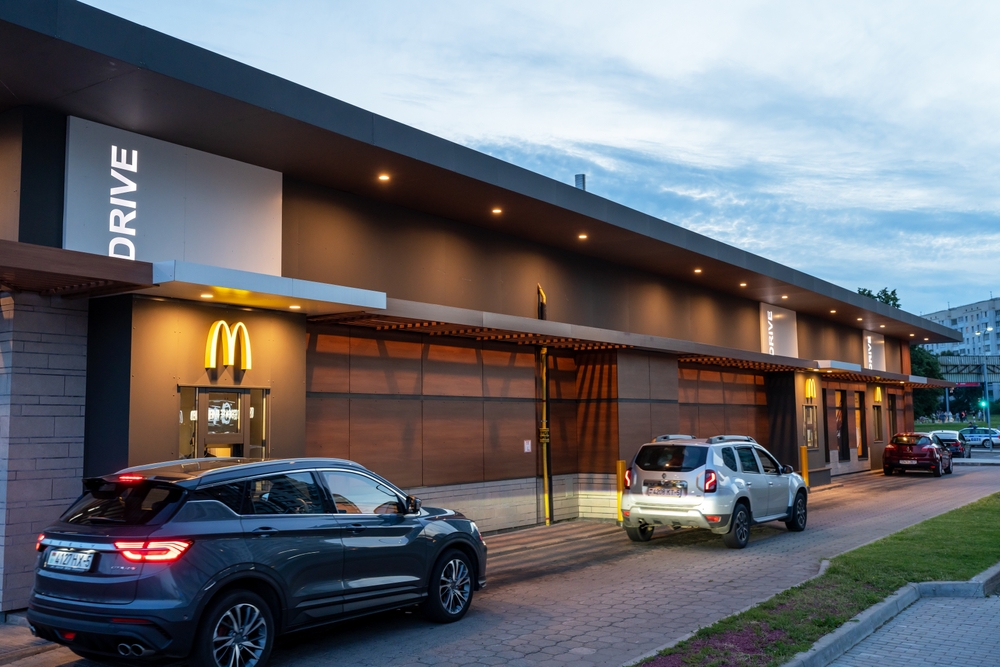 A Mcdonald's Drive-Thru where can be seen waiting for their orders. 