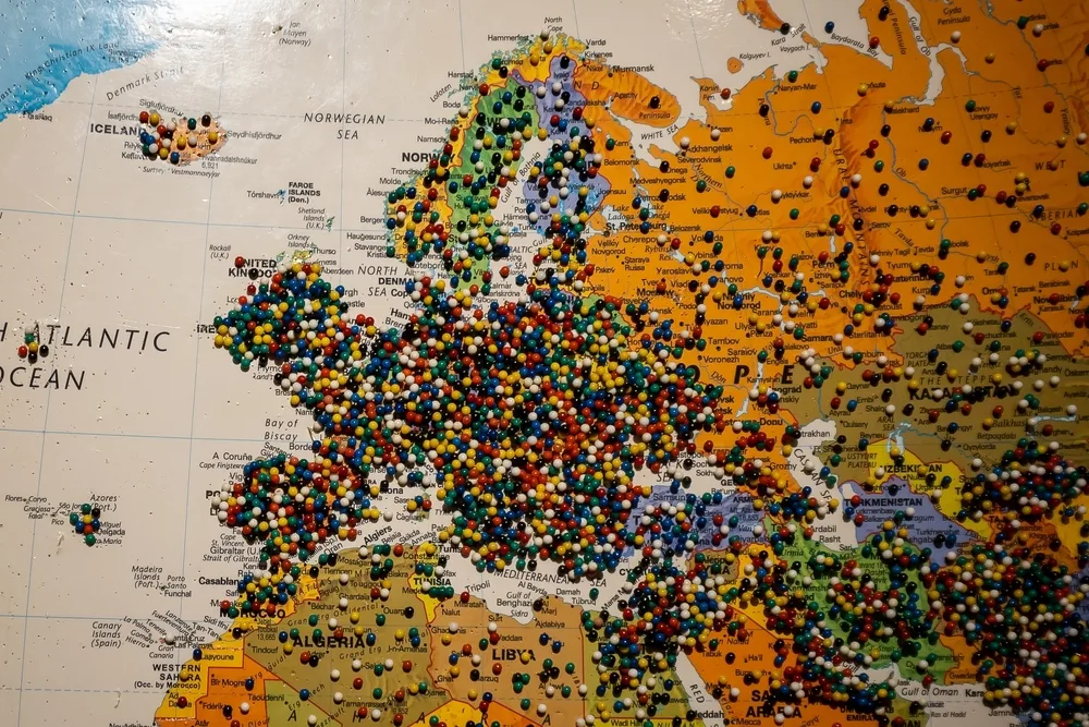 A map with different colored pins. 