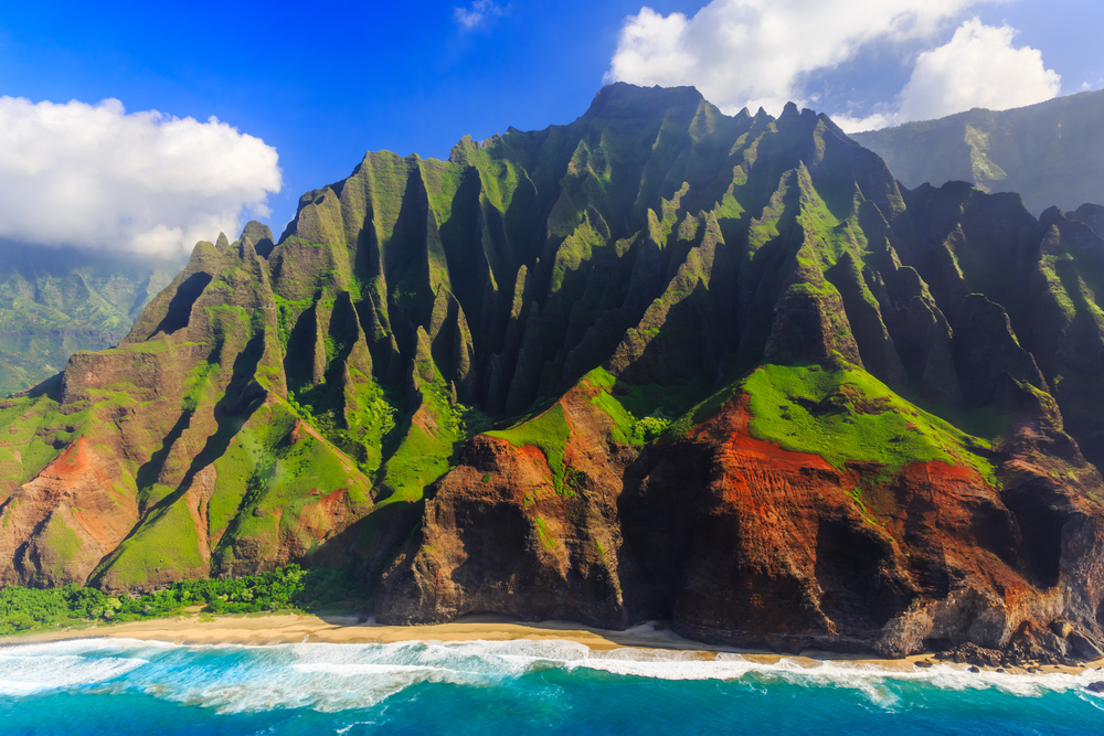 Napali Coast on Kauai shown with rugged mountains and blue water below on a nice clear day for a guide demonstrating when Hawaii became a state in 1959 with a complete timeline