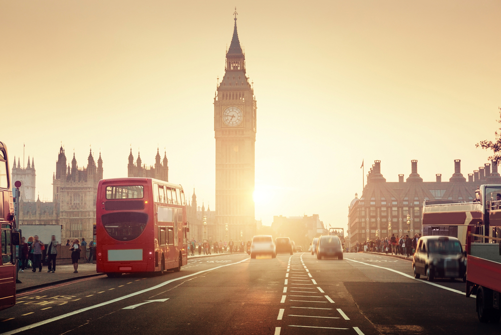 Westminster Bridge in London shown at sunset with classic double decker buses on the road and Big Ben rising for a guide offering a Europe itinerary 2 weeks long 