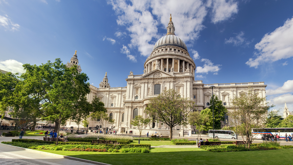 St. Paul's Cathedral shown from the exterior on a gorgeous day with a green lawn and trees around for a full Europe itinerary 2 week guide for travelers