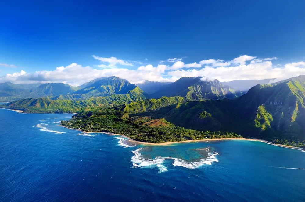 A concept of how many people live in Hawaii (Kauai) with an aerial view of the rugged wilderness and mountains along the coast of one of the least-inhabited islands in the chain