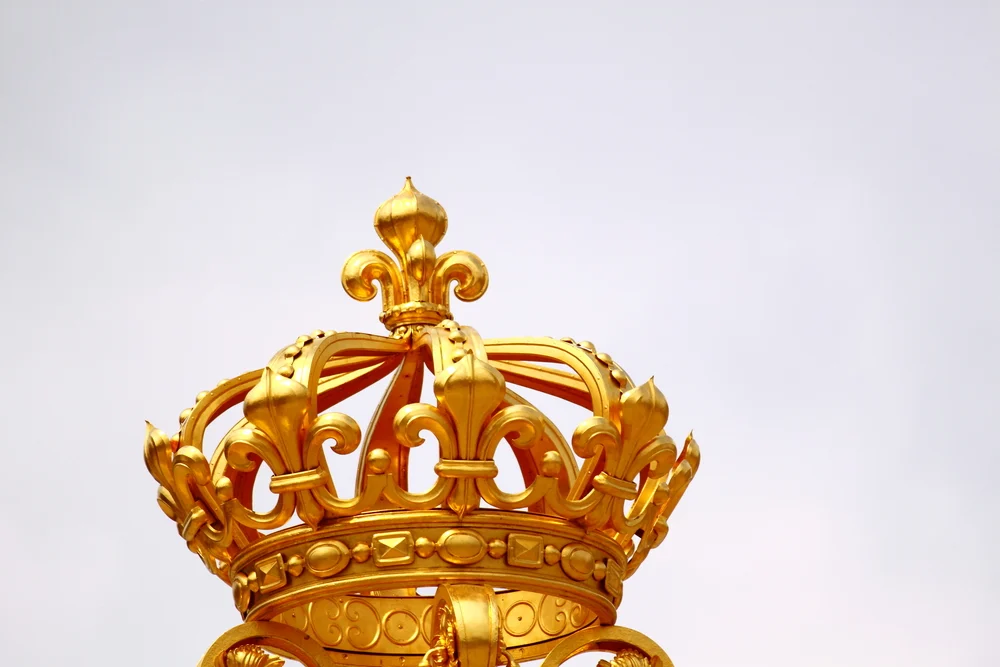 An image of a golden crown with intricate details. 