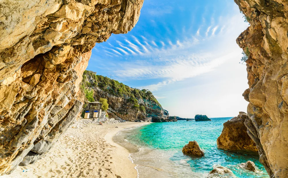 Gorgeous view of Pelion with a beige sand beach framed by two large rocks, as seen during the overall best time to visit Greece