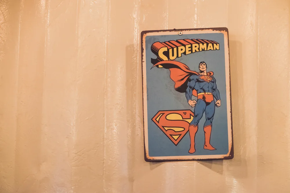 An old superman comic poster hanging on the wall. 