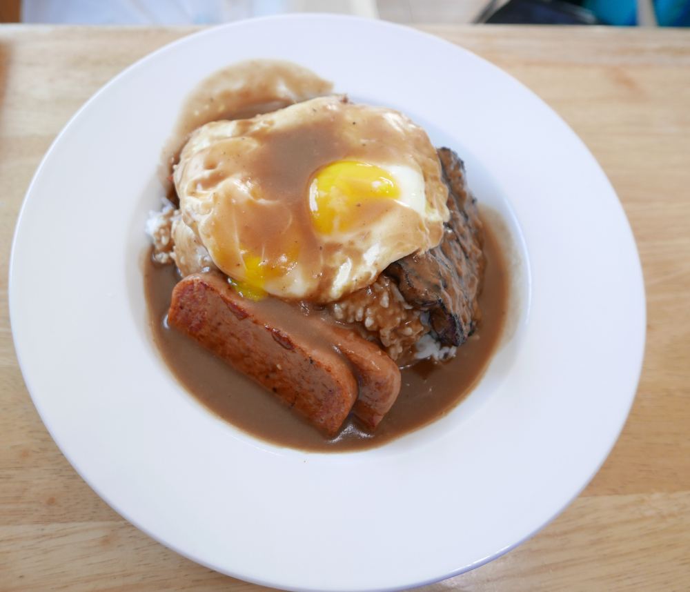 SPAM loco moco served on a white plate with eggs, rice, and brown gravy for a section showing the most popular SPAM foods in Hawaii