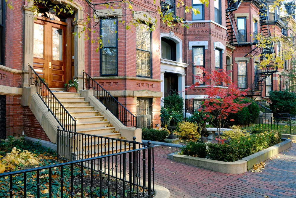 Historic brownstone apartments lining the brick paved streets in the Back Bay neighborhood during a laid-back fall weekend in Boston