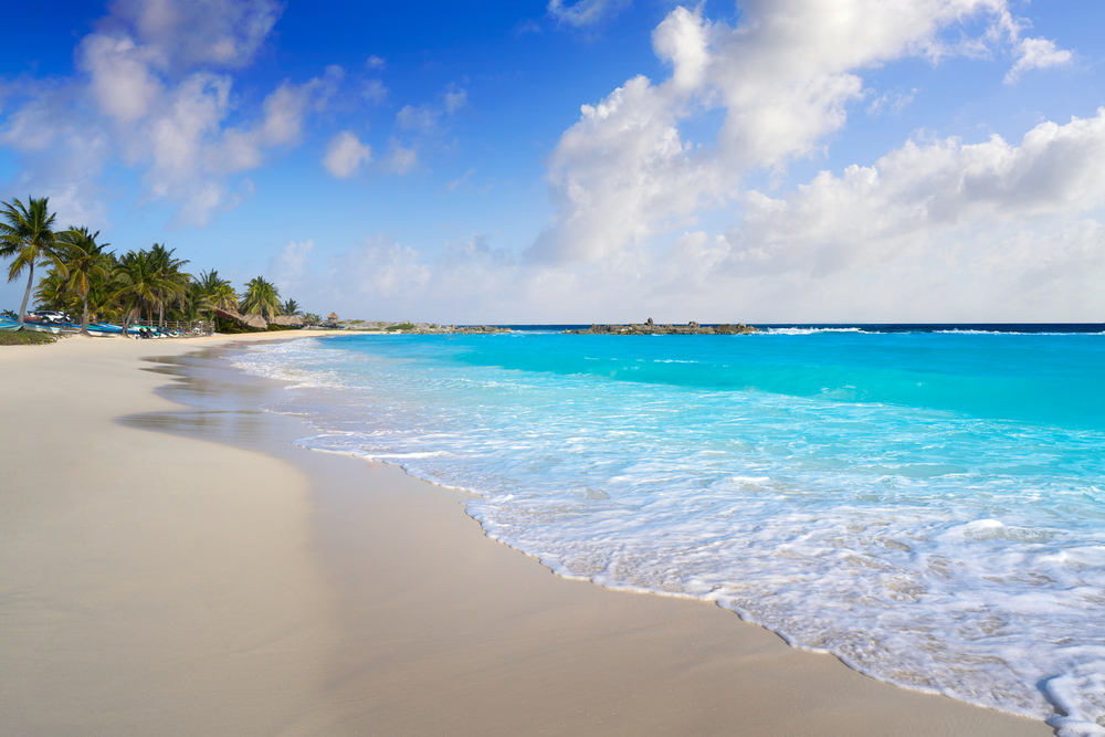 A peaceful beach with fine sand and calm waves during the best time to visit Cozumel.