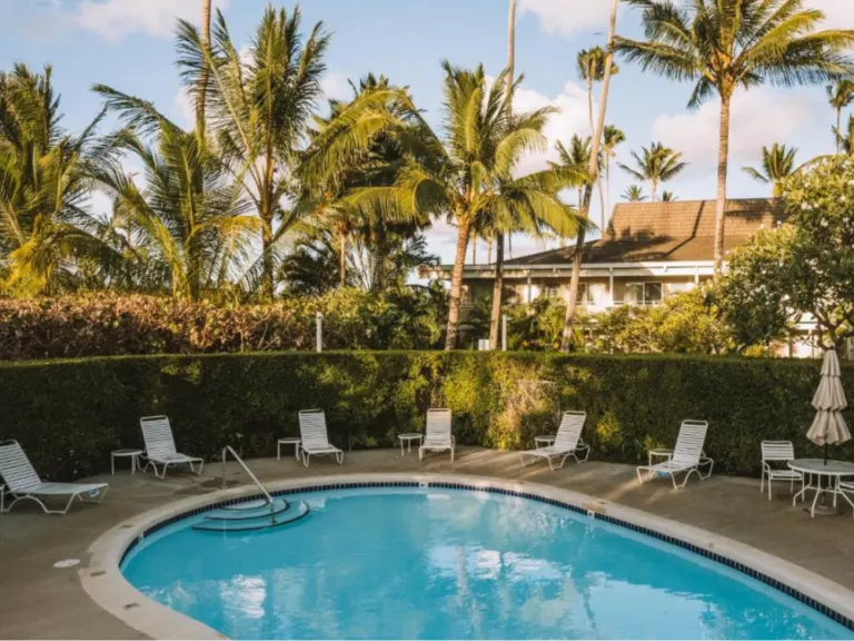 Featured as one of the best places to stay in Hawaii, a pool and building at Plantation Hale Suites on Kapaa pictured in the day