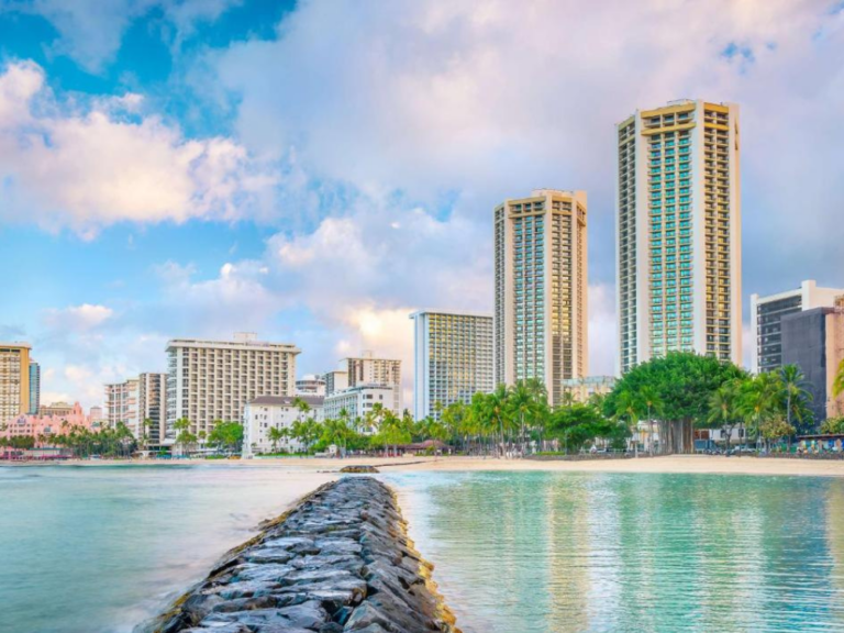 Neat view of the skyscrapers on the horizon towering over the still water of Waikiki Bay at the Hyatt Regency, one of the best places to stay in Hawaii