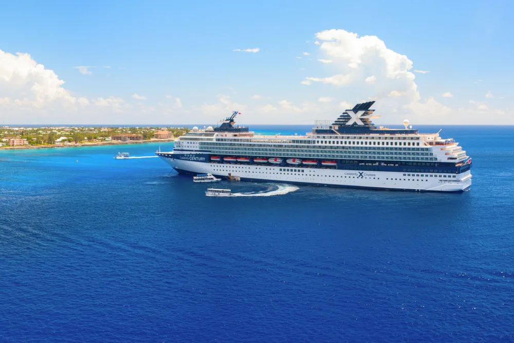 A large cruise ship approaching an island.