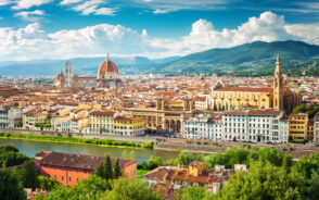 Aerial view of the historic center of Florence, Italy with clouds in the blue skies overhead depicting one of the best cities to visit in Italy
