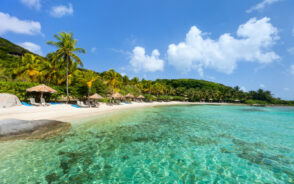 For a guide titled What Are the Caribbean Islands, a photo of a beach in the BVI pictured below a picturesque blue sky