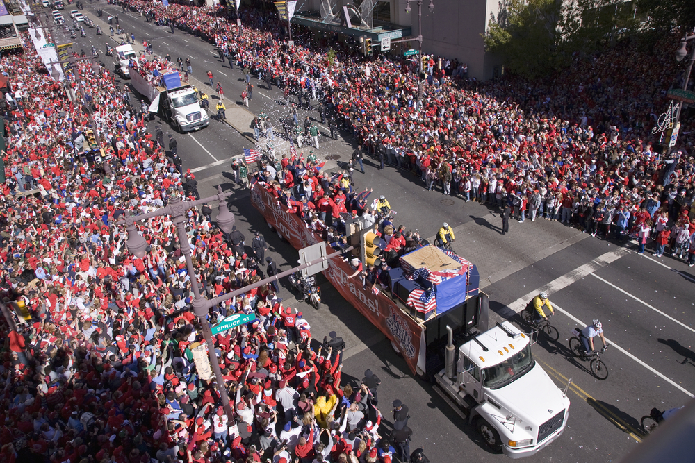 Photo of truckloads on Phillies fans making their way through the crowd of rowdy fans on Broad Street for a guide titled Is Philadelphia Safe to Visit