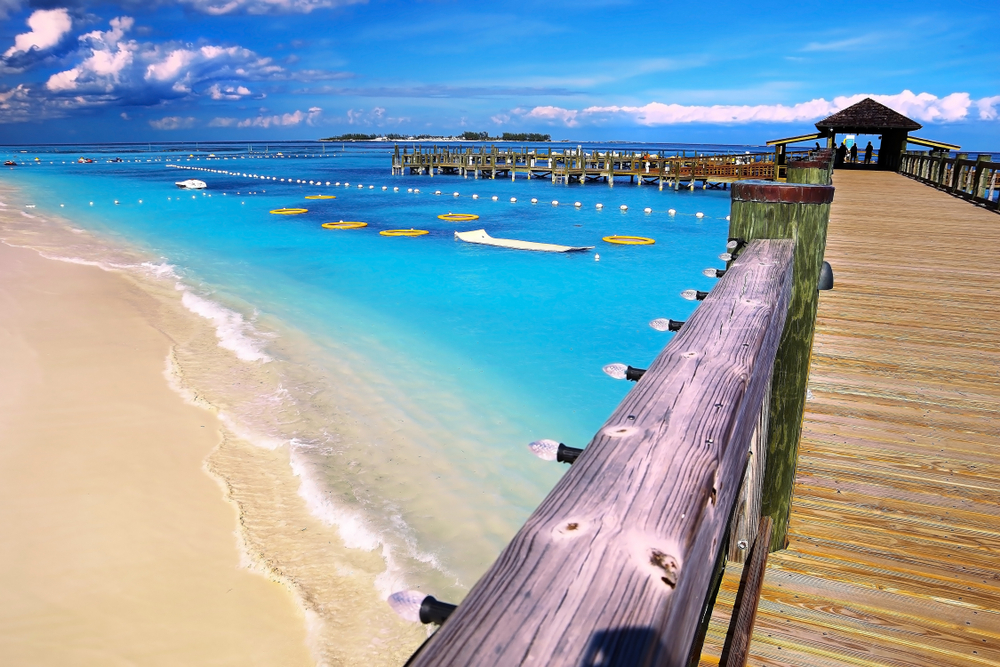 Pier over the gorgeous teal water of Cable Beach, pictured during the best time to visit the Bahamas