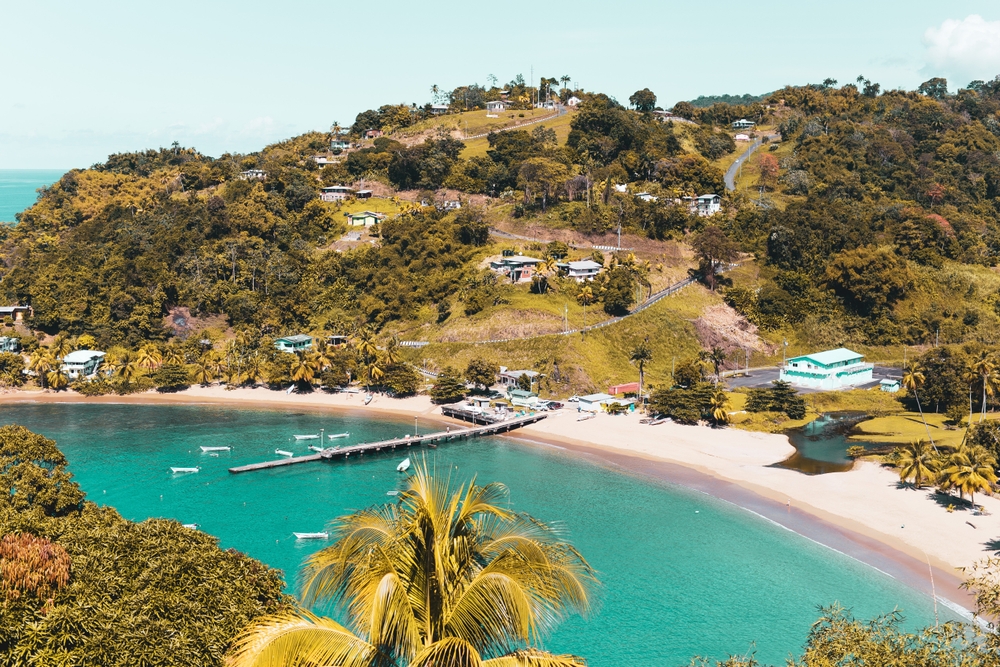 To help answer What Are the Caribbean Islands, a photo of Trinidad and Tobago is seen with a white sand beach and the gorgeous Caribbean water lapping the shore