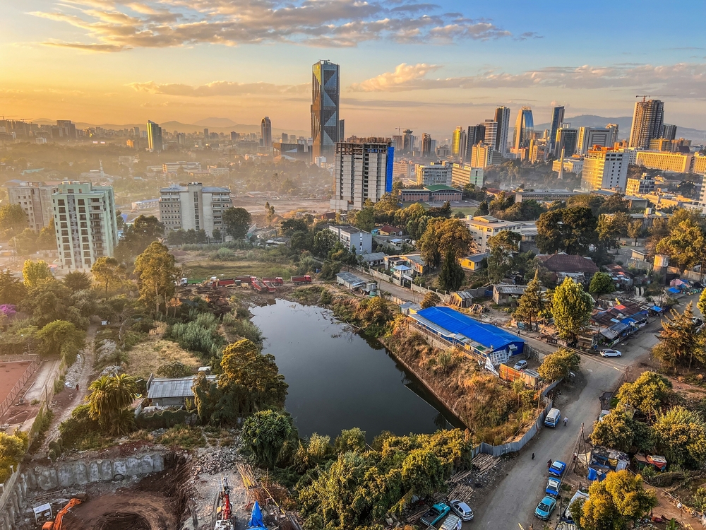 Aerial image of Addis Abeda, the capital of Ethiopia, pictured with tall buildings in the background and shanties in front for a guide titled Is Ethiopia Safe to Visit