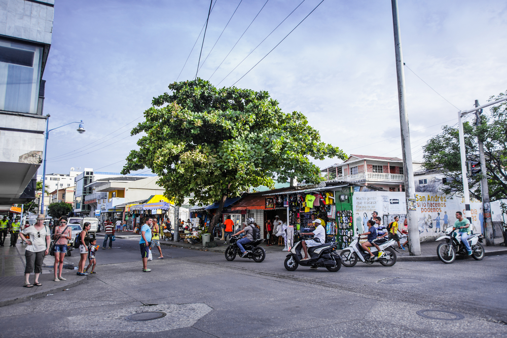 Photo of a busy intersection pictured with people mulling about in San Andres for a guide titled Is Colombia Safe to Visit