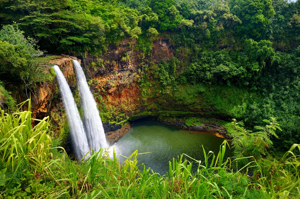 Twin Wailua Falls cascading into a pool on Kauai, Hawaii for a guide discussing whether or not you need a passport to travel here 