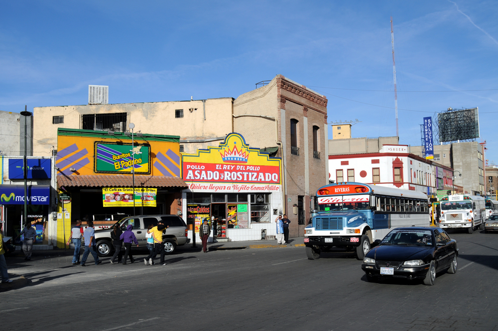 Photo of a bus and people mulling about in Cuidad Juarez, pictured for a guide on whether or not El Paso is safe to visit