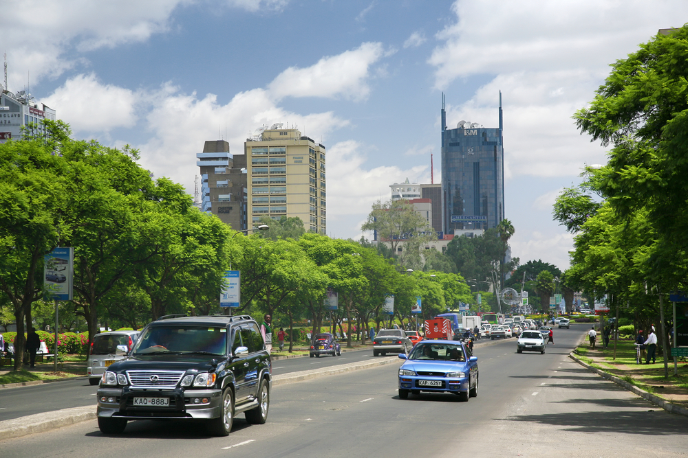 Cars driving down the street outside of big towers overlooking the windy road in Nairobi, part of a guide titled Is Kenya Safe to Visit